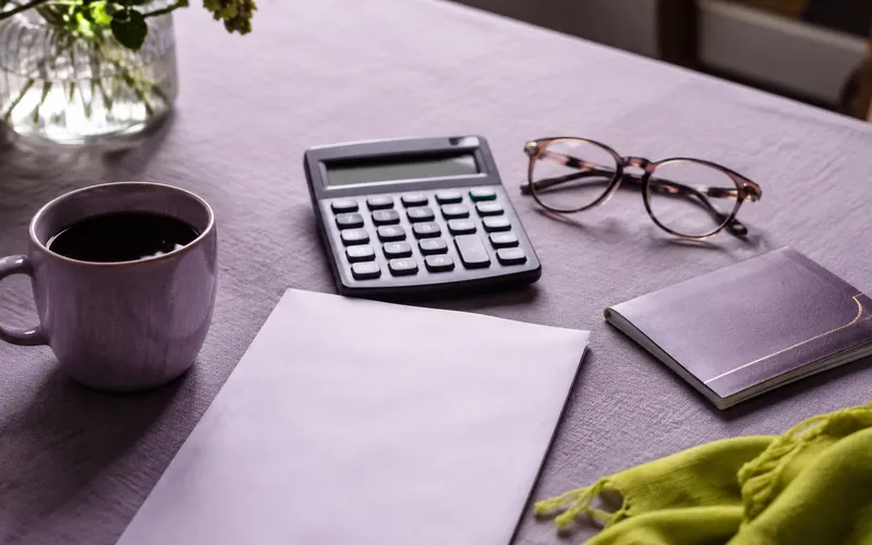 Calculator, glasses and a printed estimate on a kitchen table